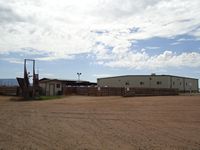 Receiving area with loading chute and sale barn in background
